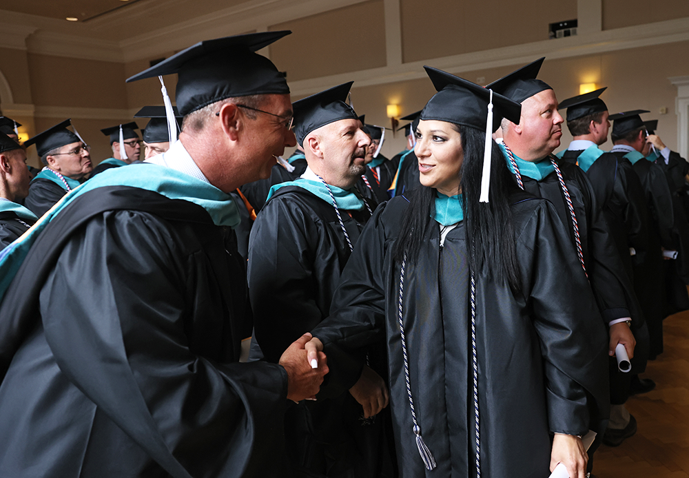 Afsoon Ansari shaking hands with fellow graduate