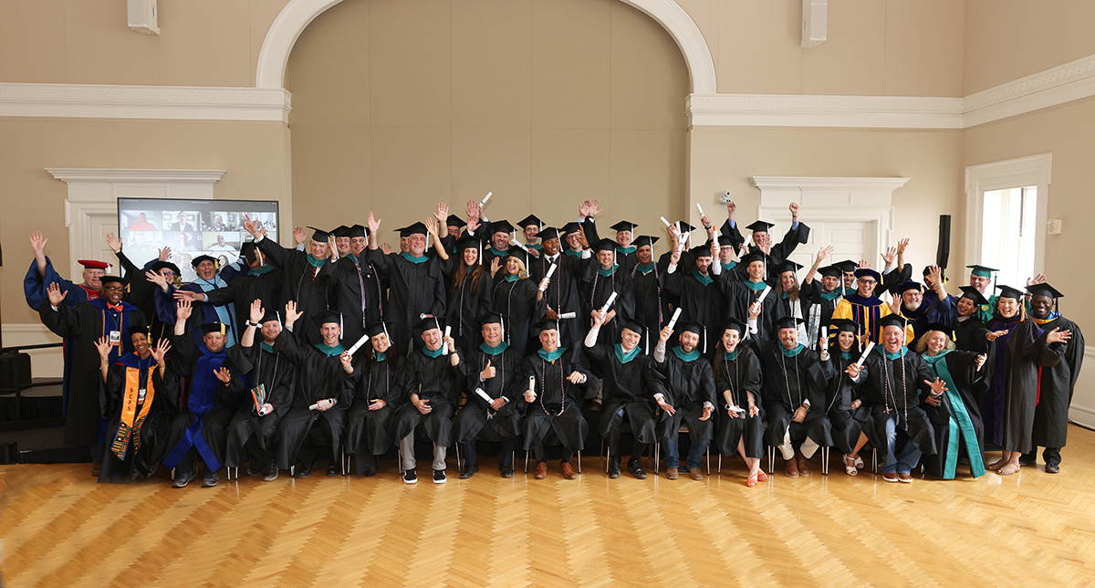 2024 MPS Graduates raising their diplomas in celebration